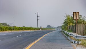 Serene landscape of an empty expressway in Deeg, India with lush greenery.