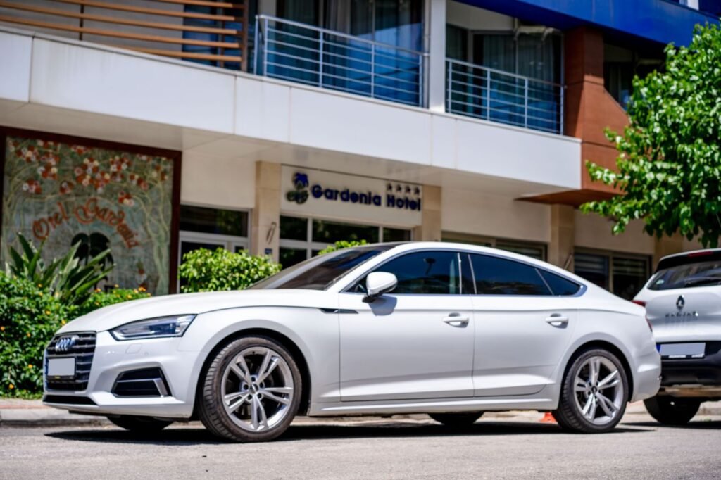 Business Hotel White luxury car parked in front of a hotel with modern architecture.