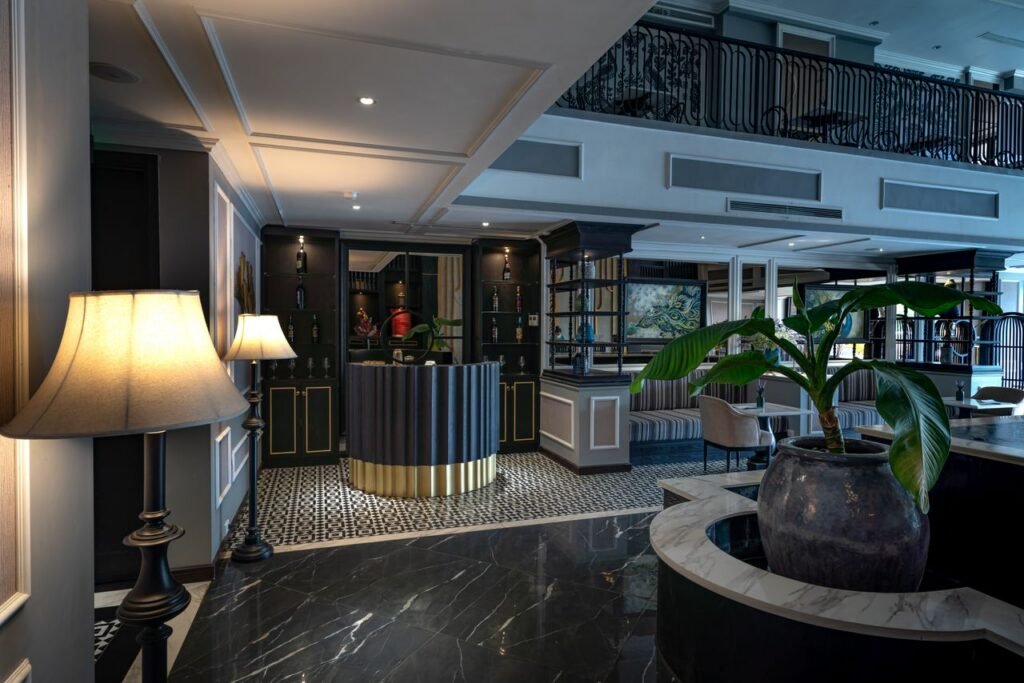 Hotels and Hospitality Sophisticated hotel lobby featuring elegant design with floor lamps and houseplants.