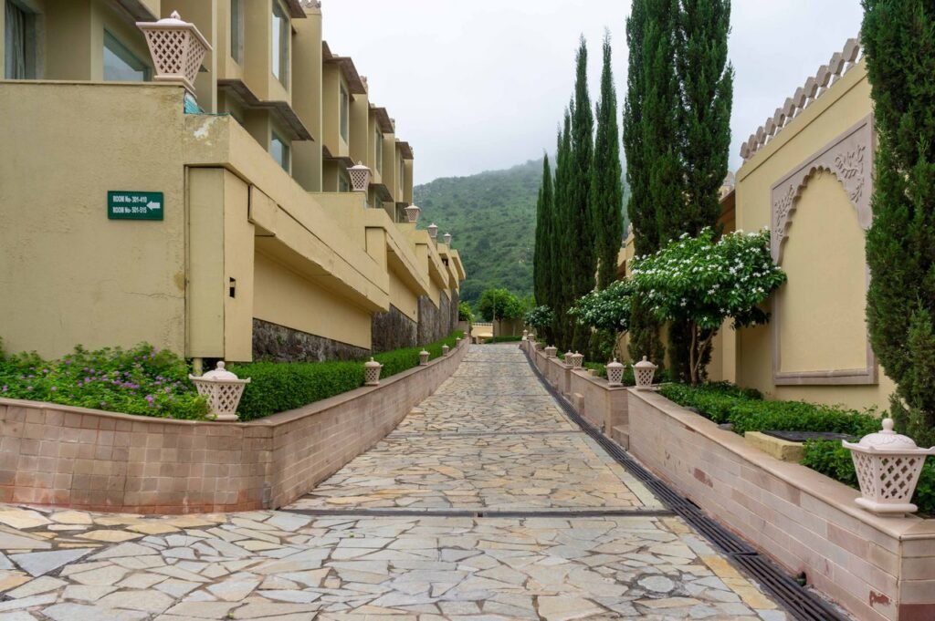 pexels-photo-30607291-30607291 Elegant resort pathway adorned with greenery and mountain backdrop in Kumbhalgarh.