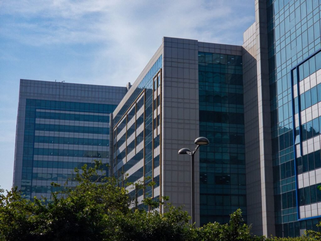 pexels-photo-30617547-30617547 Stylish modern office buildings with glass facades against a clear blue sky, exemplifying urban architecture.